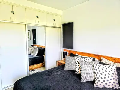 a bedroom with a bed with pillows and a mirror at NEW Luxury at Sosua Ocean Village Laguna City in Sosúa