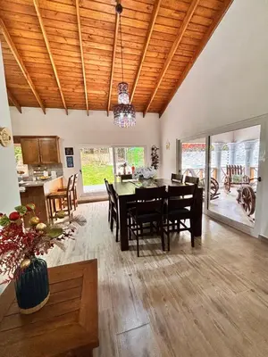 a dining room and living room with a table and chairs at Villa escondida in San Cristóbal