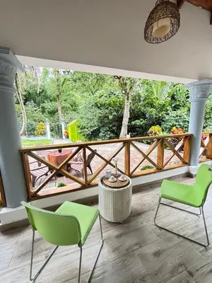 two green chairs and a table on a balcony at Villa escondida in San Cristóbal