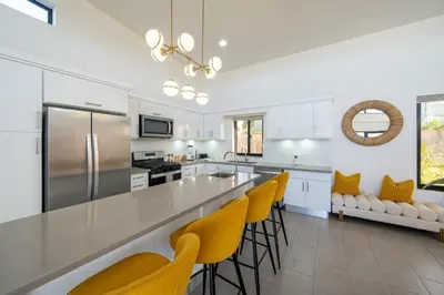a kitchen with a large counter and yellow chairs at Privacy, Big, Exclusive in Sosúa in Sosúa