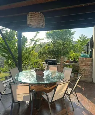 a glass table and chairs on a patio at Emmanuel villas luxury in Puerto Plata
