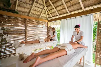 a man and two women laying on beds in a room at Mahona Boutique Hotel in Las Terrenas