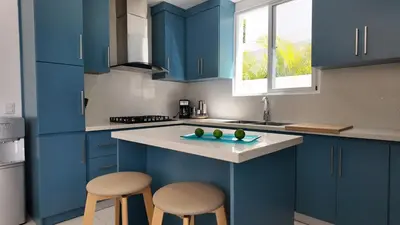 a kitchen with blue cabinets and two stools at Beach House With Private Pool in Las Terrenas