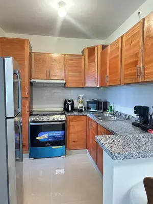 a kitchen with wooden cabinets and a blue stove at Vista Azul Boca Chica Accommodation in El Higo