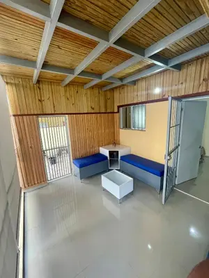 an empty room with blue benches and a table at La Casita De Chucho in Santiago de los Caballeros