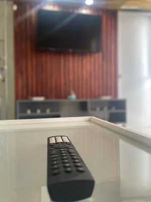 a remote control sitting on a table in front of a television at La Casita De Chucho in Santiago de los Caballeros