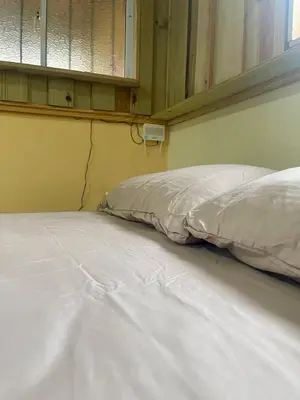 an unmade bed in a room with a window at La Casita De Chucho in Santiago de los Caballeros