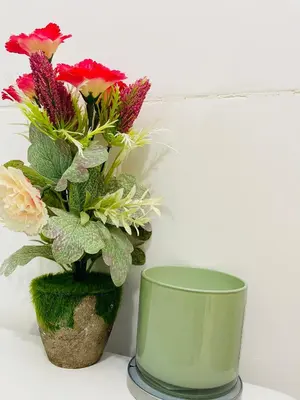 a green vase with flowers in it on a table at Hospedaje Fdez Bta En Pedernales in Pedernales