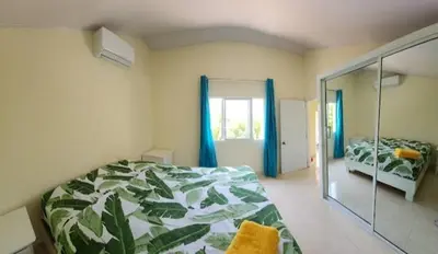 a bedroom with a bed and a window and a mirror at Villa Janel in Punta Rucia
