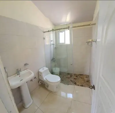 a bathroom with a toilet and a sink and a shower at Villa Janel in Punta Rucia