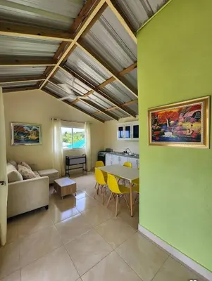 a living room with a table and yellow chairs at Villa Janel in Punta Rucia