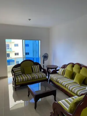 a living room with two couches and a coffee table at Comodo apartamento en Boca Chica SDQ AILA in El Higo