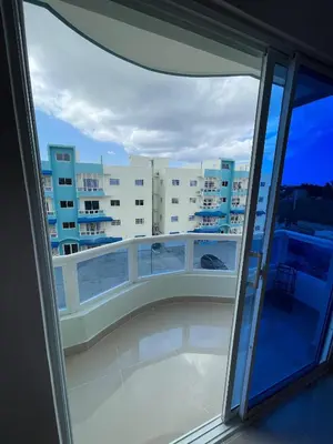 a balcony with a view of a building at Comodo apartamento en Boca Chica SDQ AILA in El Higo