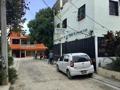 a white car parked on the side of a street at Aparta hotel El Sol, Home near AirPort SDQ in Boca Chica