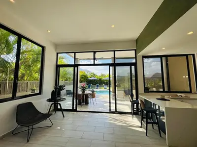 a kitchen and dining room with a view of a pool at Villa Aguacate Near the Beach in Juan Dolio