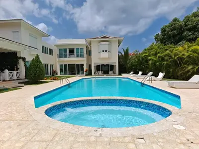 a swimming pool in front of a house at Casa de Campo Luxury Villa with private Pool & Jacuzzi, Near Beach, Marina, Golf, Restaurants & Altos de Chavon in La Romana