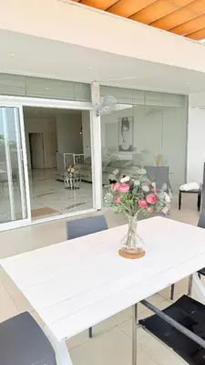 a white table with a vase of flowers on it at SoHo Loft Penthouse in Santo Domingo