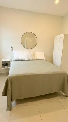 a bedroom with a large bed with a mirror on the wall at SoHo Loft Penthouse in Santo Domingo