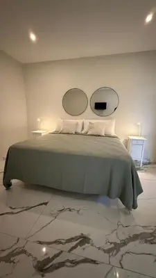 a bedroom with a bed with two mirrors on the wall at SoHo Loft Penthouse in Santo Domingo