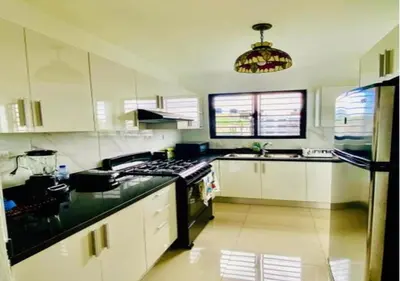 a kitchen with white cabinets and a black stove top oven at Hermoso Apartamento de tres habitaciones in La Viva