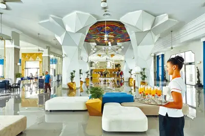 a person standing in a lobby with a table and chairs at Riu Palace Punta Cana - All Inclusive in Punta Cana