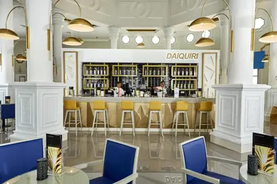 a bar in a restaurant with blue chairs at Riu Palace Punta Cana - All Inclusive in Punta Cana