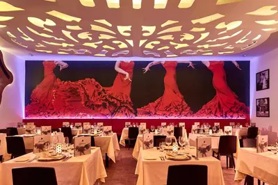 a dining room with white tables and a large screen at Riu Palace Punta Cana - All Inclusive in Punta Cana