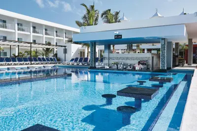 a swimming pool with a bar in a hotel at Riu Bambu - All Inclusive in Punta Cana