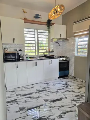 a kitchen with white cabinets and a marble floor at Rest in Paradise, Pool, Beach and Terrace in Sánchez