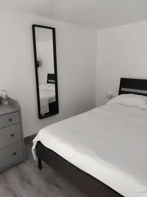 a bedroom with a white bed and a mirror at Hostel capicua in Punta Cana