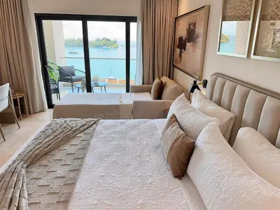 a hotel room with two beds and a view of the ocean at Stylish Studio Samaná Bay View, Pool and Gym Access in Santa Bárbara de Samaná