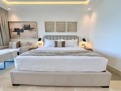 a bedroom with a large bed and a couch at Stylish Studio Samaná Bay View, Pool and Gym Access in Santa Bárbara de Samaná