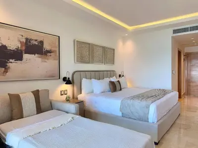 a bedroom with two beds and a couch at Stylish Studio Samaná Bay View, Pool and Gym Access in Santa Bárbara de Samaná