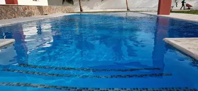 a swimming pool with blue water in a building at Casa Perez CCC in Juan Dolio