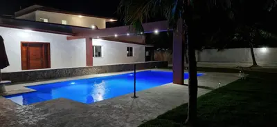 a swimming pool in front of a house at night at Casa Perez CCC in Juan Dolio