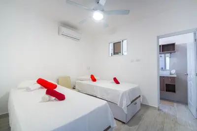 a room with two beds with red pillows on them at Le Camere Del Maestro in Bayahibe