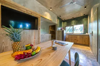 a large wooden table with a bowl of fruit on it at REFUGIO Sabaneta de Yasica in Cabarete