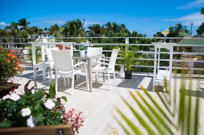 a patio with white chairs and a table on a balcony at Art Villa Dominicana in Punta Cana