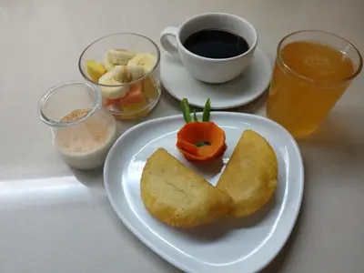 a table with a plate of food and a cup of coffee at Art Villa Dominicana in Punta Cana