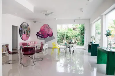 a dining room with pink and yellow chairs and tables at Art Villa Dominicana in Punta Cana