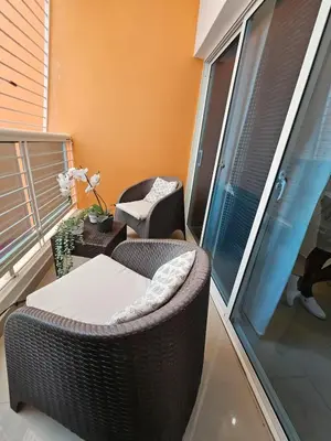 a balcony with a wicker chair and a table at Luxury apartment in Santo Domingo Este in Juan López