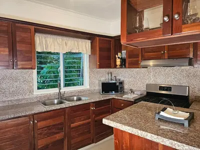 a kitchen with wooden cabinets and a counter top at Luxury apartment in Santo Domingo Este in Juan López