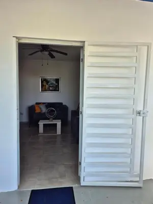 a door leading to a living room with a couch at OMY Apartments Nagua 2A in Nagua