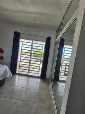 a room with two windows and a bed and a mirror at OMY Apartments Nagua 2A in Nagua