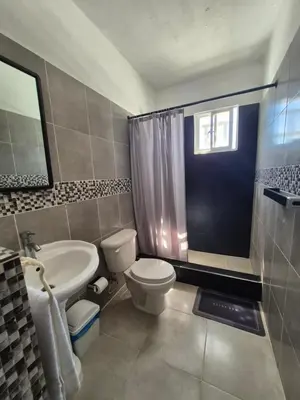 a bathroom with a white toilet and a sink at OMY Apartments Nagua 2A in Nagua