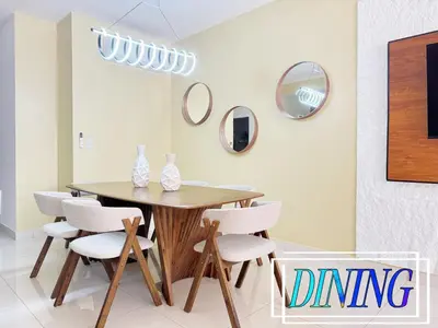 a dining room with a wooden table and white chairs at Beachfront apartment Sunset in Colorado