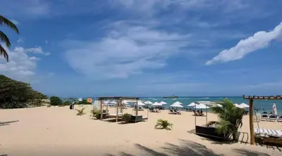 a beach with chairs and umbrellas and the ocean at Beachfront apartment Sunset in Colorado