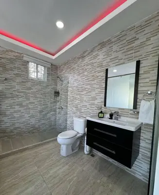 a bathroom with a toilet and a sink and a mirror at villas el guano in Sosúa