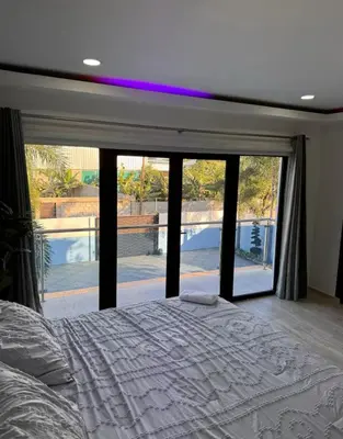 a bedroom with a bed and a large window at villas el guano in Sosúa