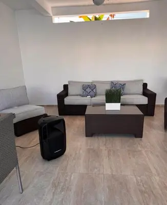a living room with a couch and a tv at villas el guano in Sosúa